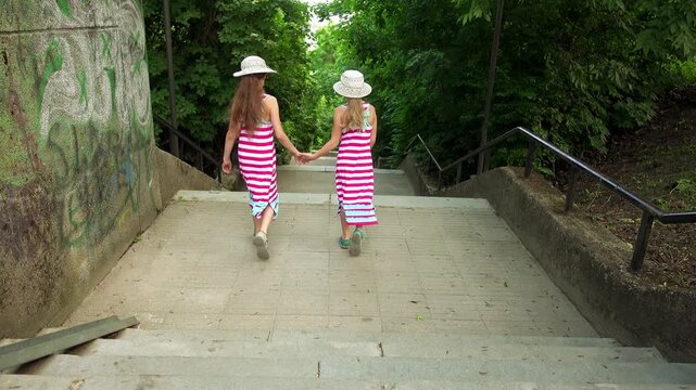 Two little beautiful girls walking down stairs