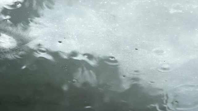 Heavy rain drops falling on glass window
