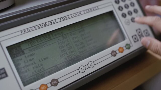 Factory technician setting up an industrial machine using a digital control panel in a workshop
