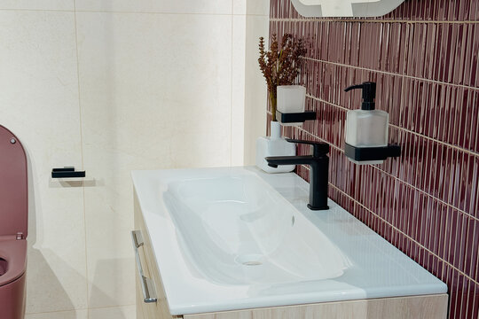 Modern bathroom with pink toilet and patterned wall tiles