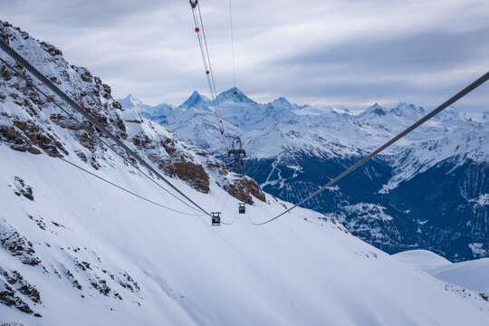 Panoramic view from Funitel Violettes-Plaine Morte with aerial lift pylon in Crans-Montana, Switzerland over Rhone Valley towards Matterhorn mountain against cloudy skys