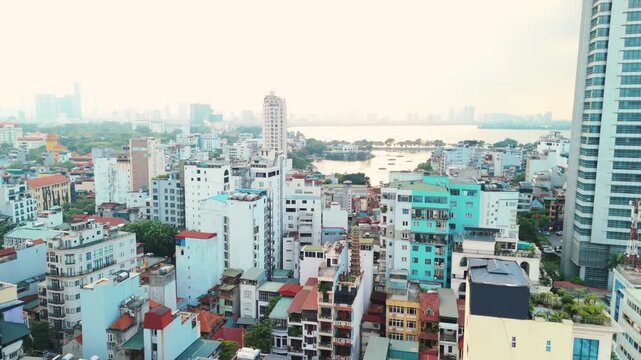 Hanoi central city district skyline presenting dense urban architecture and residential buildings overlooking the wide expanse of west lake on a hazy day