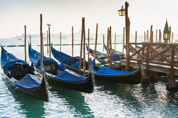 Venetian gondolas moored on Grand canal in Venice, Italy. Beautiful cityscape at sunset. © smallredgirl