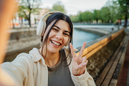 Young woman taking selfie showing peace sign