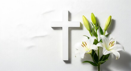 A white wooden cross beside white lilies and their green buds on a white surface © Alistair