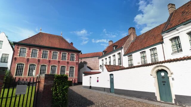 Historic Kortrijk beguinage pan shot, revealing UNESCO‑listed heritage under clear daylight.