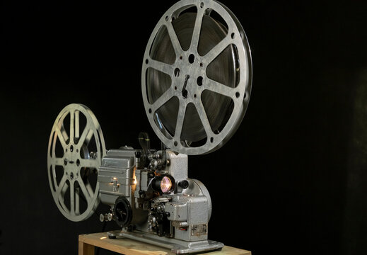 Vintage film projector on display in a dark room showcasing the art of film in the 20th century
