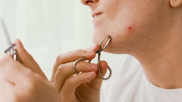 4K close-up of a woman removing unwanted chin hair with tweezers during a home beauty routine, addressing facial hair problems and hormonal changes. High quality footage