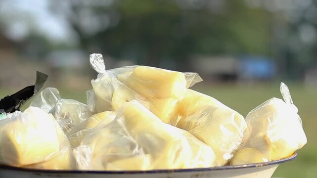boiled cassava in plastic with blur of people walking