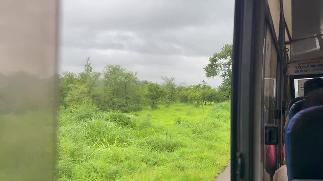Bus window seat and experiencing India's country side during monsoon season near Raigad, Maharashtra