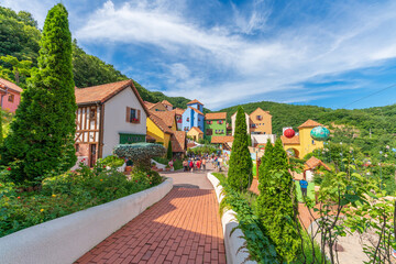Scenic perspective of Petite France theme park featuring vibrant pastel buildings and French traditional architecture surrounded by green mountains, landmark in Gapyeong, Republic of Korea. © PREECHA