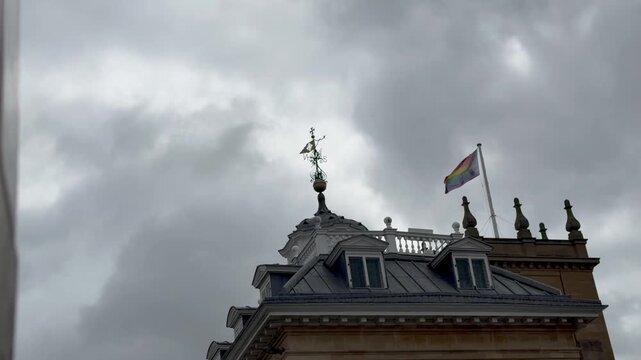 The Progress LGBTQ+ Pride flag on the roof of Abingdon County Hall Museum in Abingdon-on-Thames, Oxfordshire, England, during a cloudy and windy day. 
