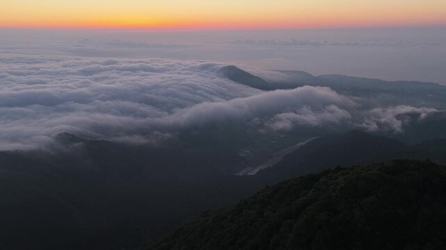 Aerial retreat over sea of clouds around Omuroyama and Yahazuyama, volcanic landscape in Ito Japan