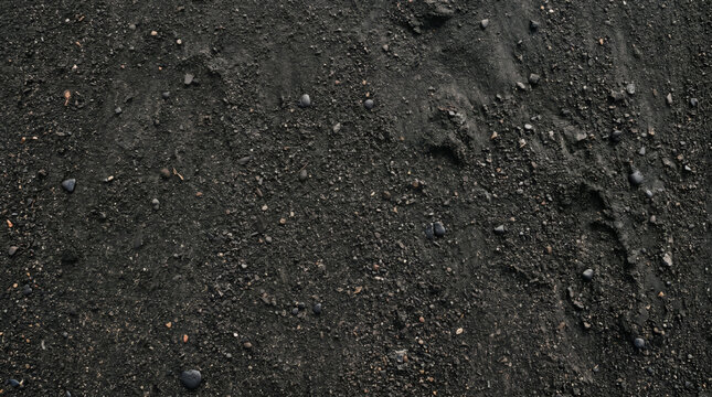 Black volcanic sand texture with small pebbles on a beach