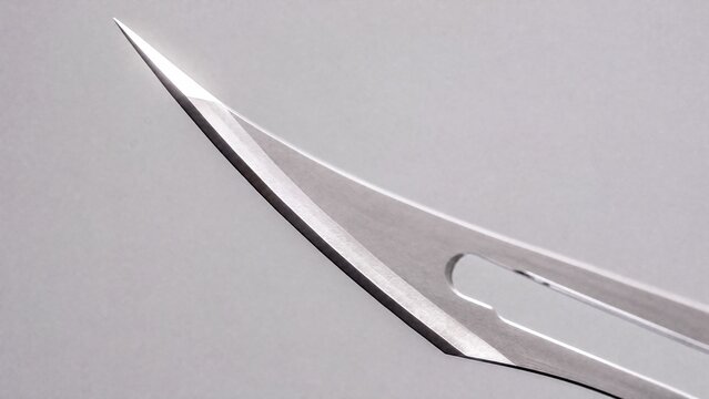 A single surgical blade under bright lighting.