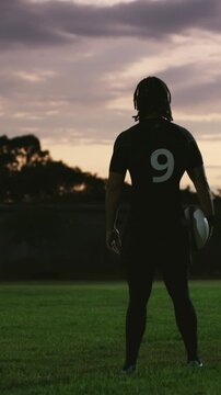 Football player, fitness and person with ball on field, back and training for sport match and health. Evening, exercise and athlete on grass for practice, wellness and preparing for game outdoor