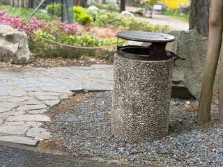 Naklejka premium Outdoor trash bin in a landscaped park