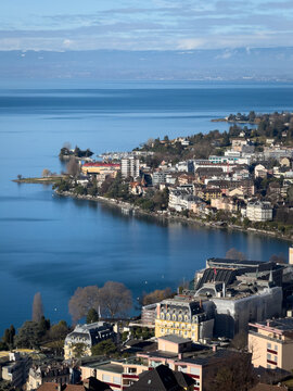 Beautiful scenic view over Montreux, Switzerland and Lake Geneva from Aire de Repos Le Pertit with lakeside cityscape and blue water against blue sky in winter