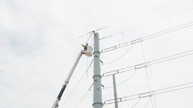 Electrical power linemen in bucket lift
