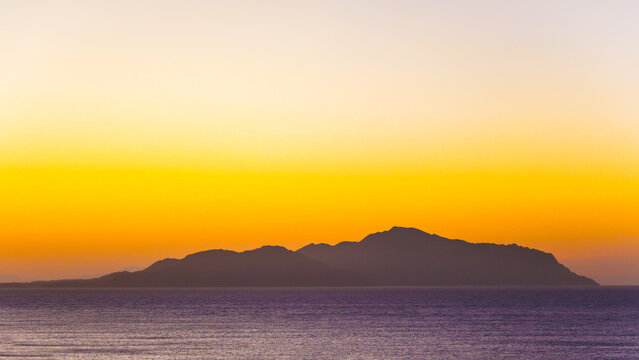 A magical sunrise over the sea with Egyptian resort hotels lining the coast. vibrant romantic resort landscape.