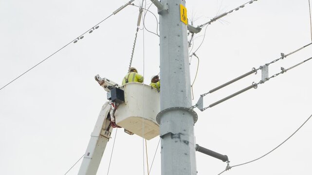 Electrical power linemen in bucket lift