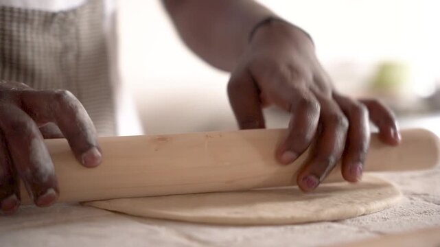 young african woman hands for baking bread or pastry with rolling pin on table in kitchen for recipe concept, homemade food preparation and livelihood and employment in africa