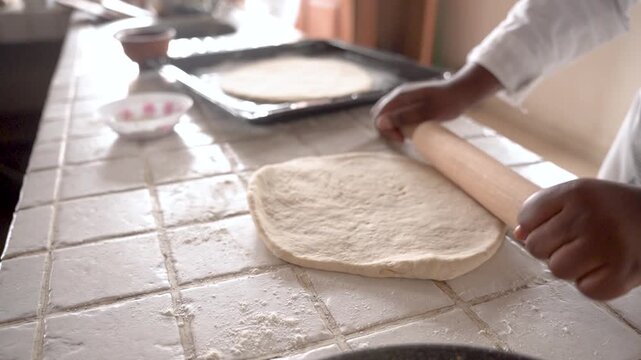 young african woman hands for baking bread or pastry with rolling pin on table in kitchen for recipe concept, homemade food preparation and livelihood and employment in africa