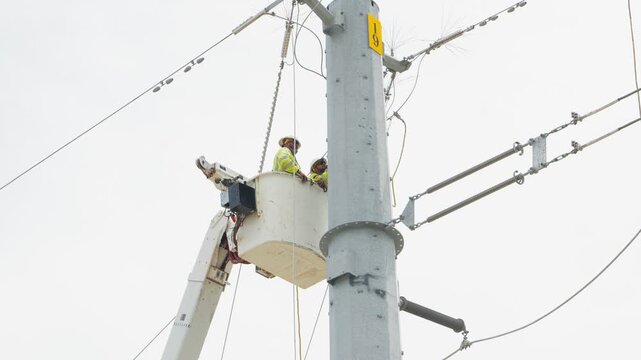Electrical power linemen in bucket lift