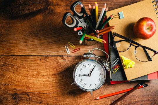 School desk flat lay with stationery and alarm clock, copy space background