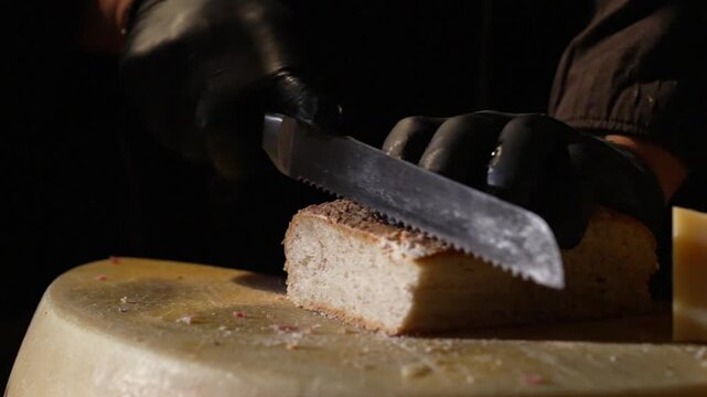 A chef cuts bread at a gourmet cheese station at a luxury party