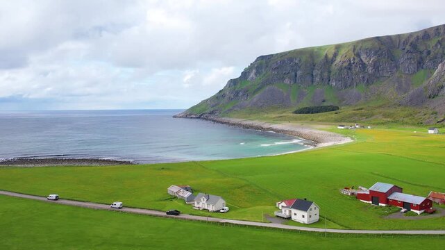 Aerial drone view of Lofoten Islands in Norway, featuring beautiful landscapes on Unstad Beach, white sand, clear water and dramatic mountains near the shore. Experience the natural beauty