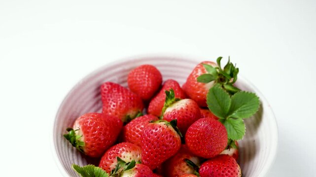 Strawberry red berry fruits in a bowl, isolated, abstract food background, close-up shot