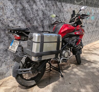 Vista lateral de moto tipo adventure o trail touring Benelli TRK 502 X con maleta GIVI y soporte met&aacute;lico para portaequipajes trasero, estacionada en Madrid, Espa&ntilde;a, 28 de abril de 2026