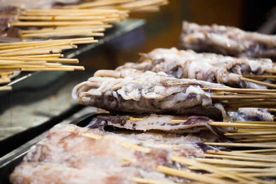 Calamari and seafood skewers grilling on hot coals, Xi'an, Shaanxi, China