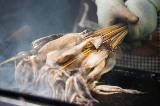 Grilled seafood skewers cooking on a market grill, Xi'an, Shaanxi, China