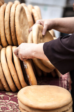 Traditional Uyghur round bread in woman's hands, Turpan, Xinjiang, China