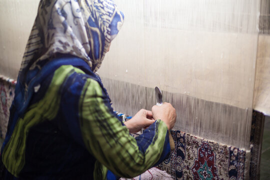 Uyghur woman weaving traditional silk on a loom in Kashgar, China