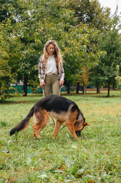 Girl walking German Shepherd in park