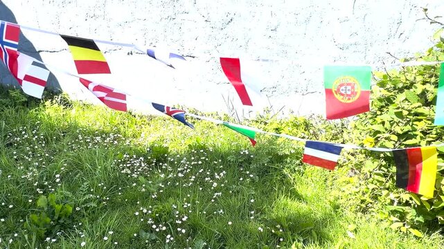 A vibrant display of international flags and decorative bunting fluttering in the breeze. Representing countries from around the world, this colourful scene celebrates unity, culture, diversity, and g
