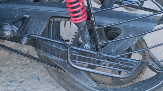 Close-up of motorcycle chain drive and rear suspension system