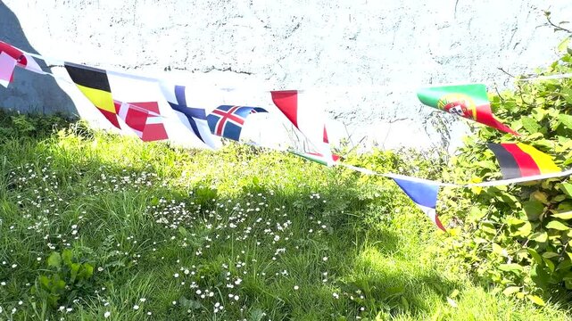 A vibrant display of international flags and decorative bunting fluttering in the breeze. Representing countries from around the world, this colourful scene celebrates unity, culture, diversity, and g