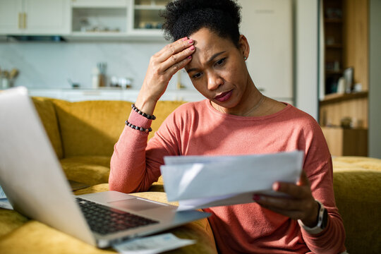 Stressed woman reviewing household bills at home