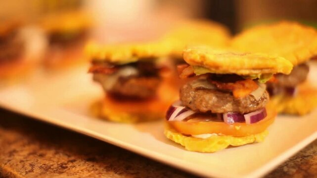 Gourmet plantain sliders with beef patties and fresh vegetables, mini tostones burgers on white plate, latin fusion appetizers for catering