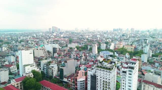 Hanoi cityscape panoramic aerial view of vietnams capital, dense mix of residential and commercial buildings stretching to the red river and distant horizon, urban growth visible