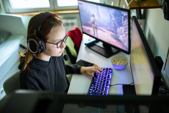 Teen girl gaming on pc at home desk