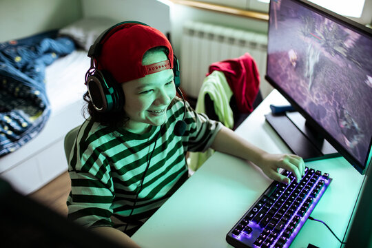 Smiling teenager gaming with headset at home