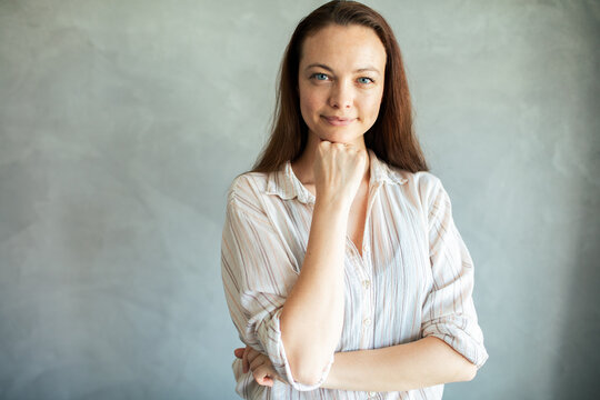 Confident young woman posing in studio with thoughtful smile