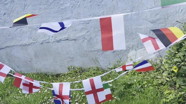 A vibrant display of international flags and decorative bunting fluttering in the breeze. Representing countries from around the world, this colourful scene celebrates unity, culture, diversity, and g