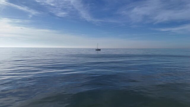 Minimal blue seascape with anchored sailboat