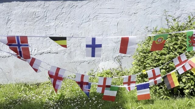 A vibrant display of international flags and decorative bunting fluttering in the breeze. Representing countries from around the world, this colourful scene celebrates unity, culture, diversity, and g
